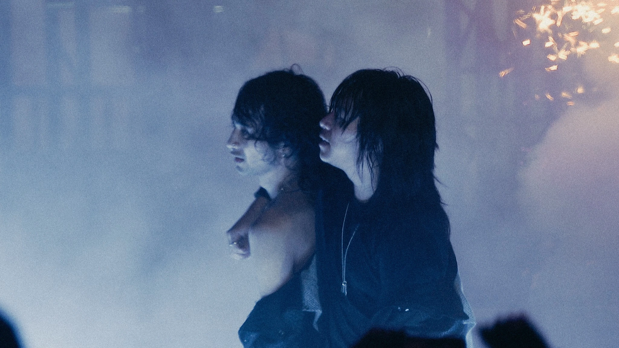 ISOxo and Knock2 standing together amid blue haze and sparks