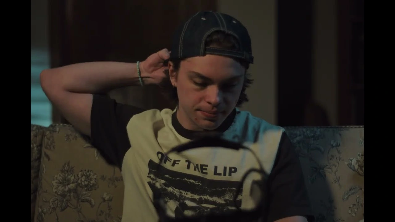 Chase Keith seated on a couch holding headphones